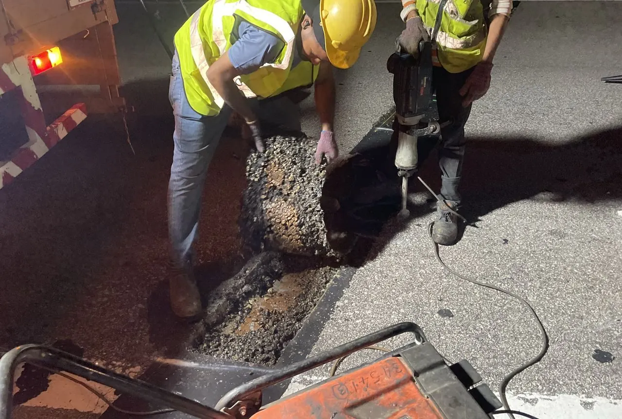 Asphaltic plug joint being poured at night